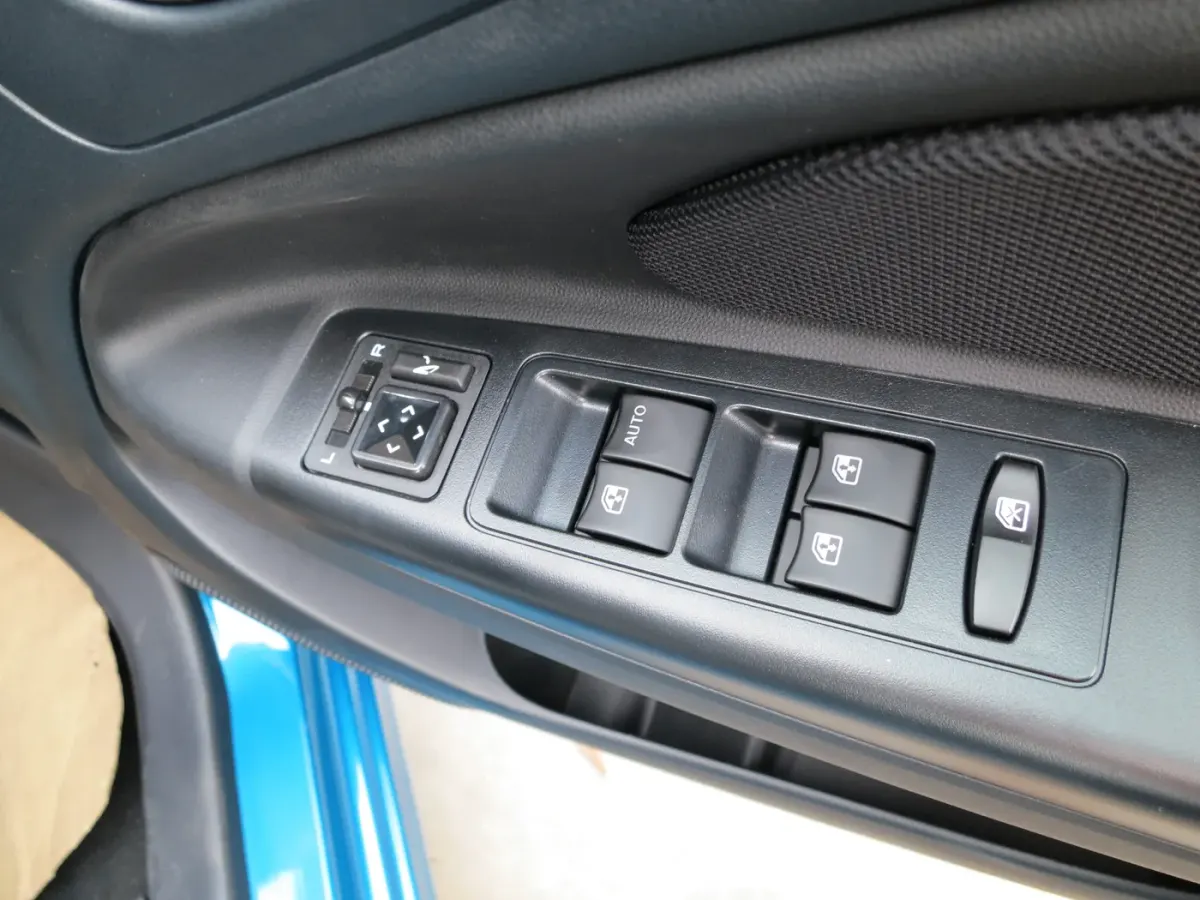 Commandes de vitres électriques et de rétroviseurs sur une portière de Proton Iriz.
