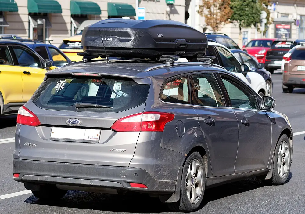 Voiture équipée d’un coffre de toit, vue de l’arrière dans la circulation.