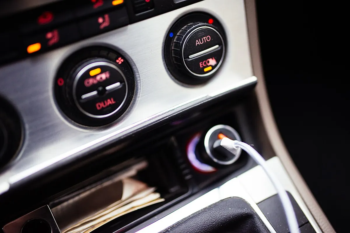 Molettes de réglage de la climatisation, avec les touches AUTO et ECON, sur une console centrale.