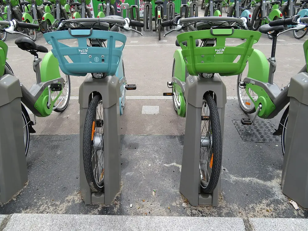 Vélos en libre-service accrochés à leurs bornes dans une station parisienne.