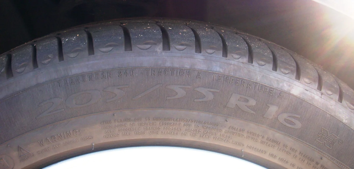 Flanc de pneu avec le marquage « 205/55R16 » et les mentions Treadwear, Traction et Temperature nettement lisibles.