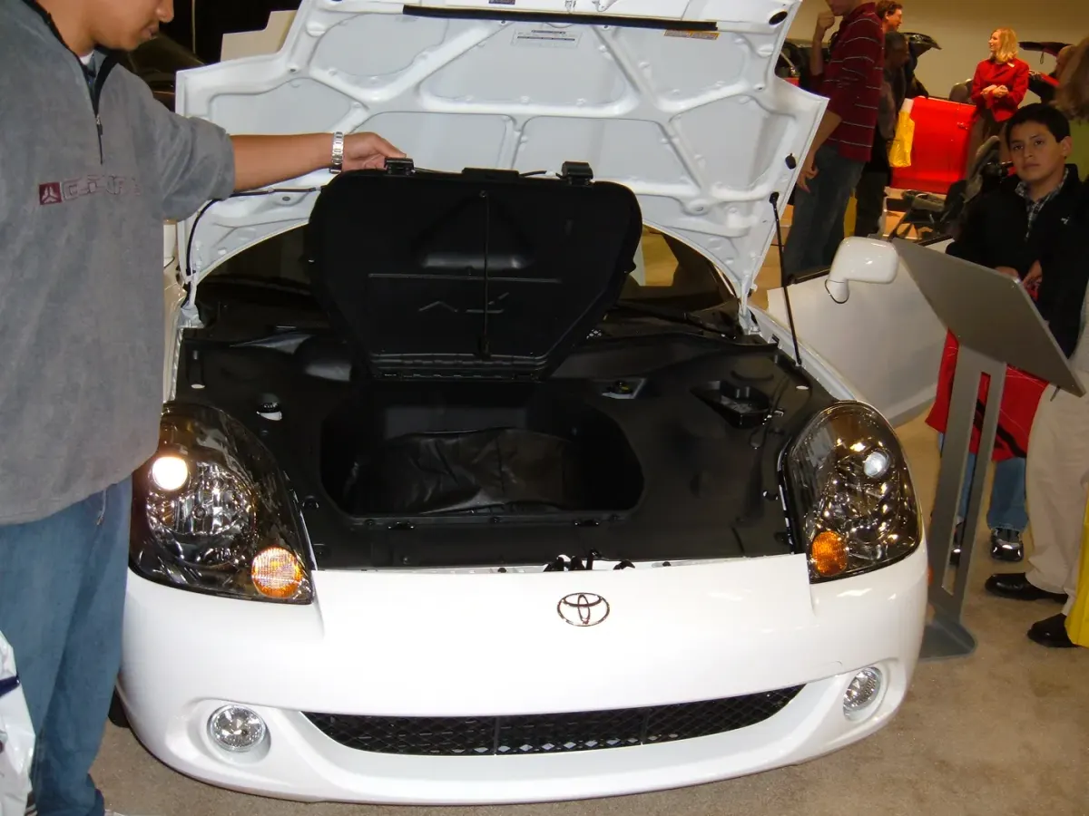 Compartiment avant ouvert d’une Toyota MR2, où peut être rangée une roue de secours.